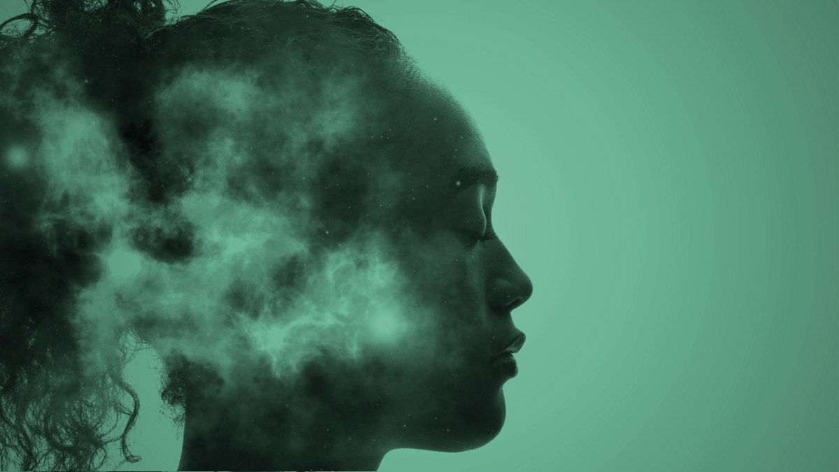 A woman in profile with her eyes closed, in soft green light