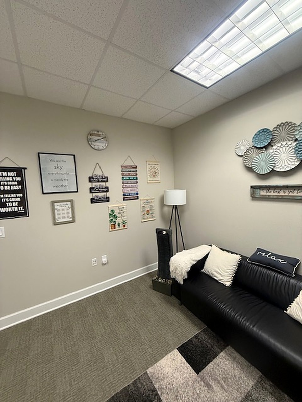 The leather-sofa room, with the wall clock and pillows